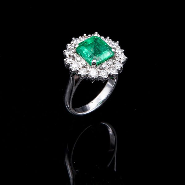 Lot 077 White gold ring, with emerald surrounded by diamonds