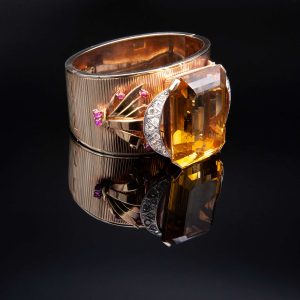 Lot 119 Yellow gold rigid band bracelet, with large quartz, diamonds and rubies